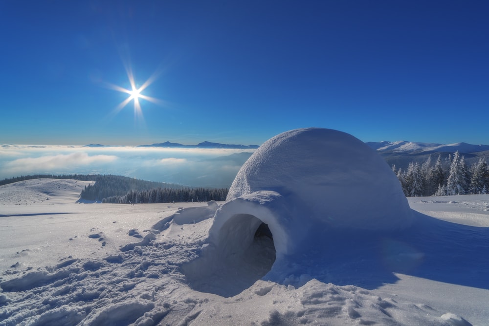 Igloo in the snow with the sun on the horizon for Element a prize for every season post